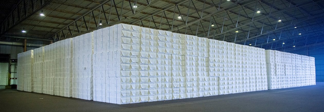 A stack of paper pulp bales in a warehouse.