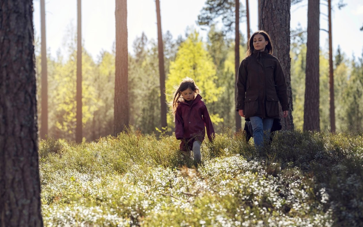 Barn och mamma är ute och går i skogen