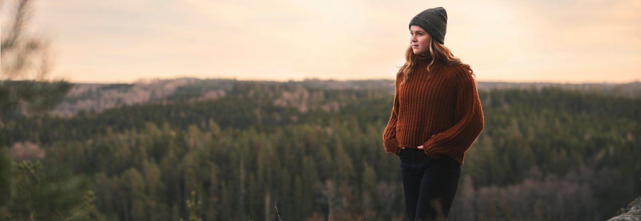 Medlem som står och tittar ut över en fin skog