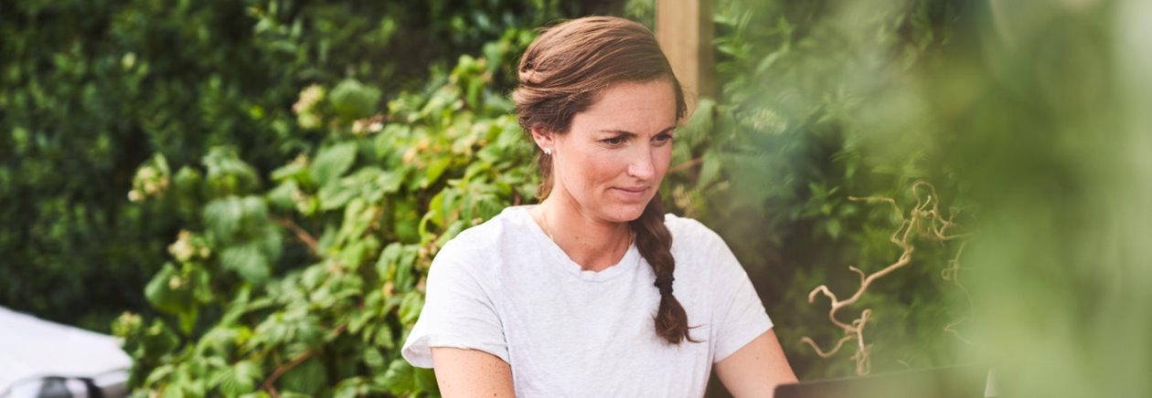 Kvinna sitter framför datorn och planerar sitt bygge ute i sin trädgård