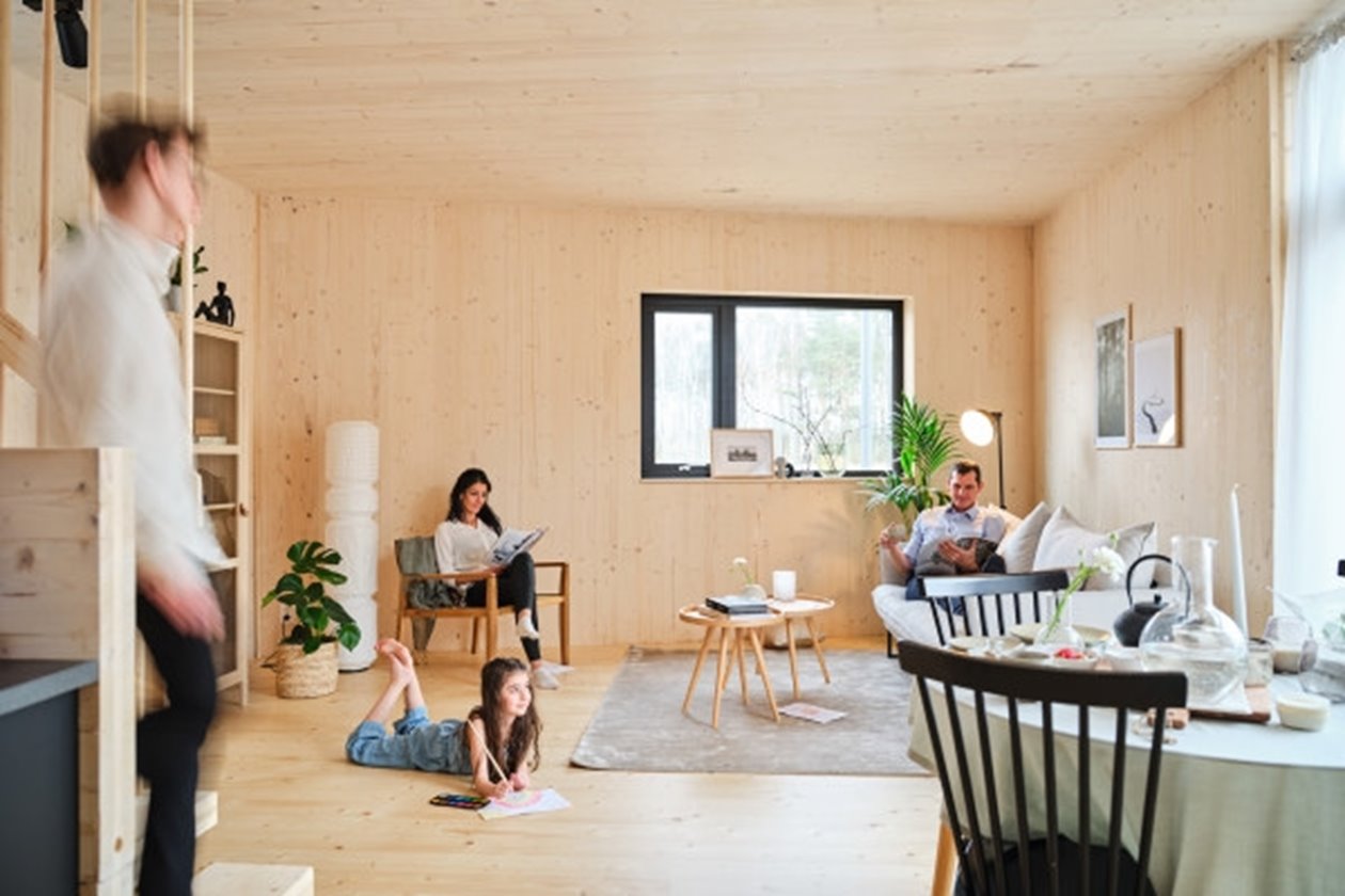 Familj i vardagsrum i en villa som är byggd i KL-trä i Båstad