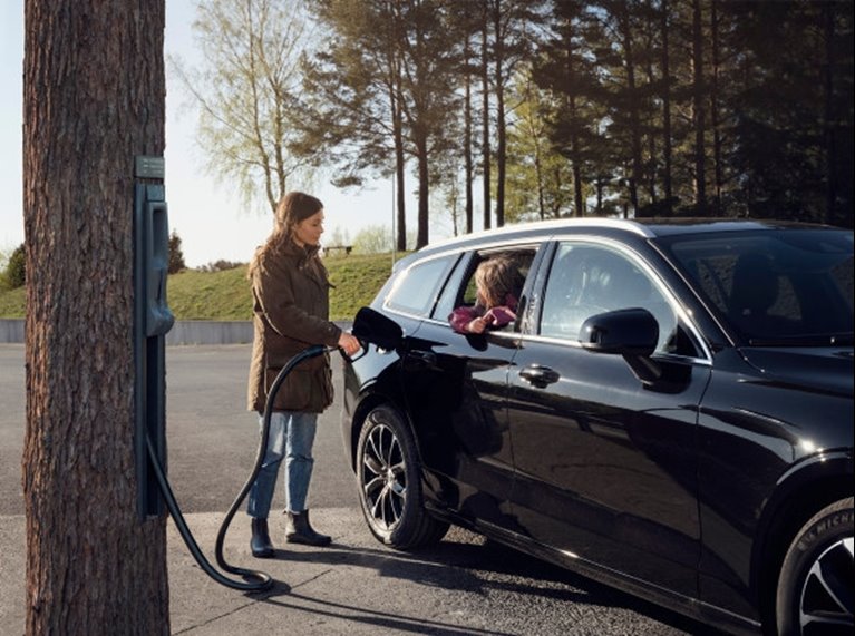 Kvinna tankar en bil med biodrivmedel från skogen Södra Cell Bioproducts