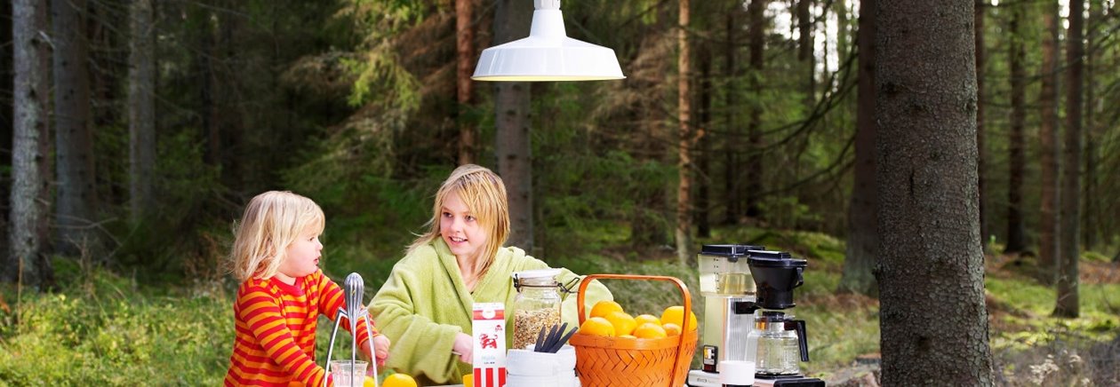 Södra El. Energi. Bild från Södra Els erbjudande till medlemmar och anställda. Frukost i skogen. Frukostbord. Taklampa. Mjölkpaket. Stol. Pall. Barn. Apelsiner. Apelsinpress. Kaffebryggare. Mossa.Trädstam. Korg. Frukostflingor. Morgonrock. Nattlinne.